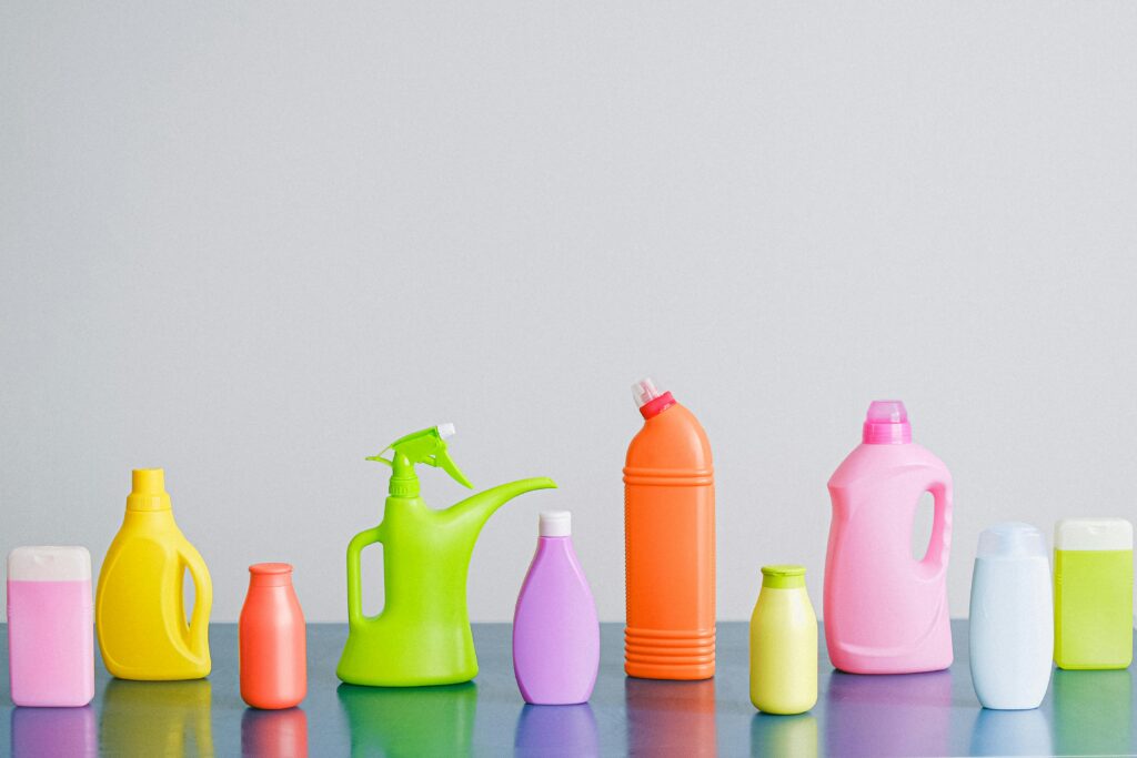 A vibrant assortment of cleaning product containers arranged on a reflective surface, perfect for household sanitation themes.
