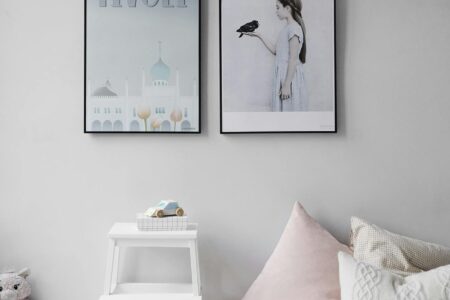 Minimalist Scandinavian bedroom with wall art and cozy decor elements.