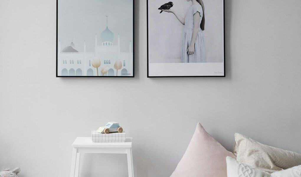 Minimalist Scandinavian bedroom with wall art and cozy decor elements.