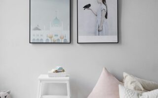Minimalist Scandinavian bedroom with wall art and cozy decor elements.