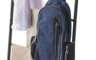 yamazaki leaning ladder rack in white leaning against a bedroom wall with folded blankets
